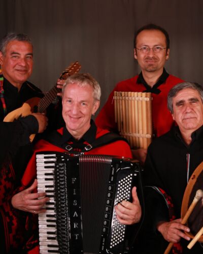 Vier mannelijke muzikanten op charango, accordeon, percussie en fluiten