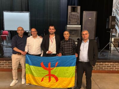 Vijf leden van Imdoukal poseren met een Amazigh-vlag.